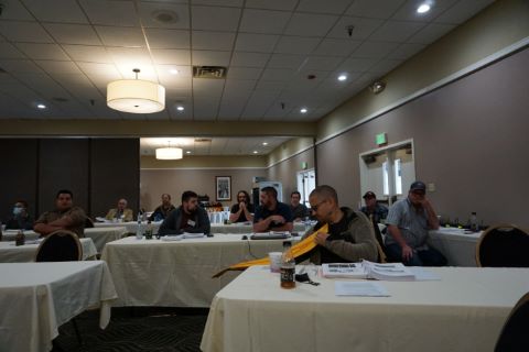 A man holds a yellow rectangle pavement marker to see the markings.