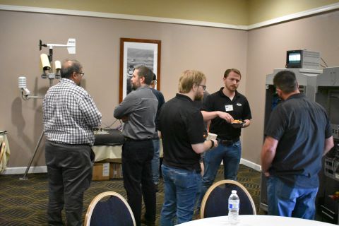 A group of men talk to one another.