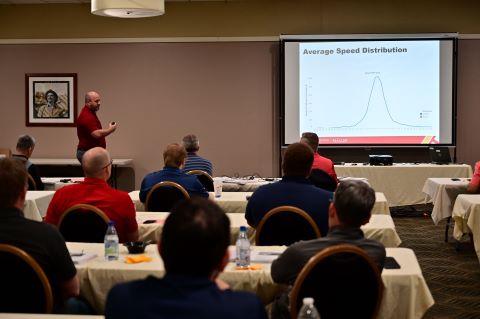 A man presents in front of a projector.