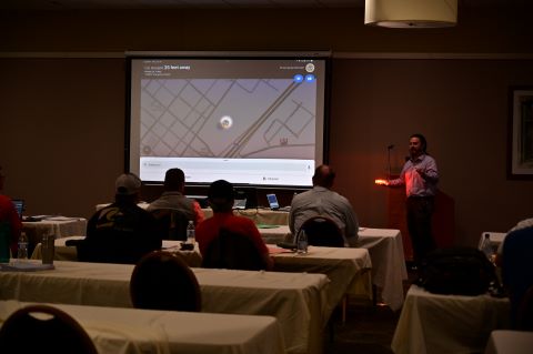 A man holds an orange light in front of an audience.
