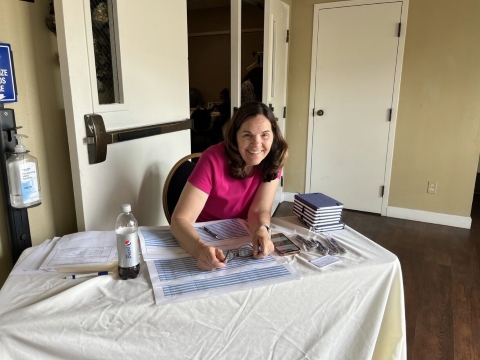 A woman poses for a photo while seated at a table.