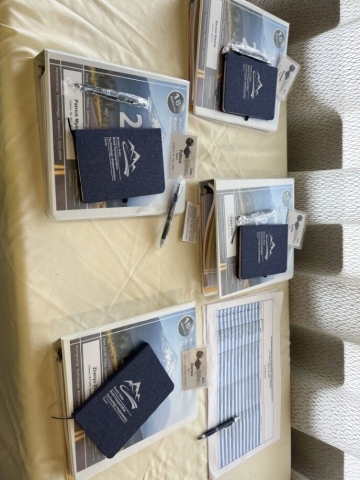 Binders and notebooks sit next to a registration sheet on a table.