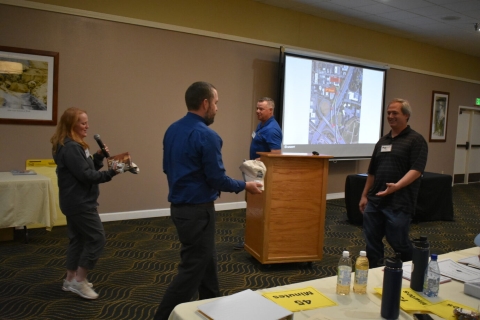 A man and a woman hand items to two men.