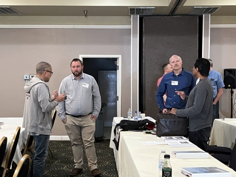 Two groups of men talk to one another.