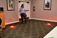 Justin Belk A man performs a demonstration with orange lights placed on the floor.